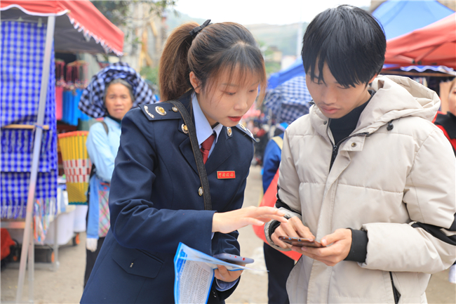该局“岭税长青”服务队成员现场辅导缴费人使用手机线上缴费.jpg
