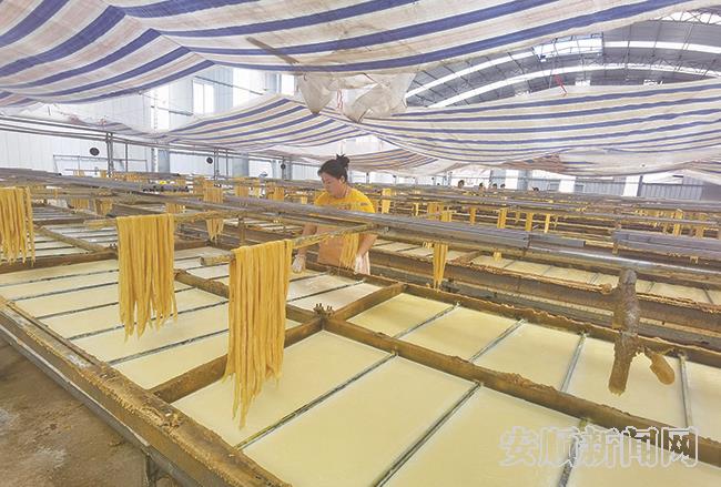 安顺鑫力食品有限公司依托安顺智慧热力公司提供热能研发、生产、销售豆制品，生产车间里工人正在制作豆腐皮.jpg