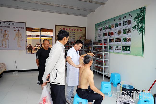 入驻市场的中草药商家正在为顾客进行按摩.jpg