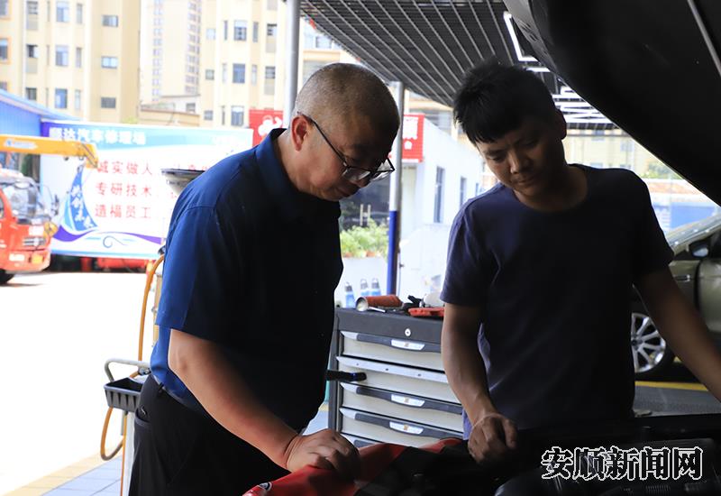陈怀能和厂里的师傅一起修车.jpg
