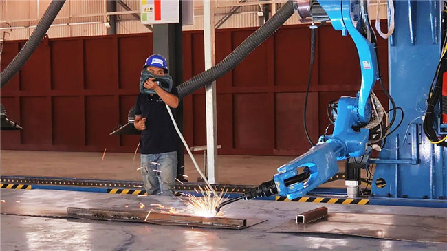工人们正操纵机器人进行焊接.jpg
