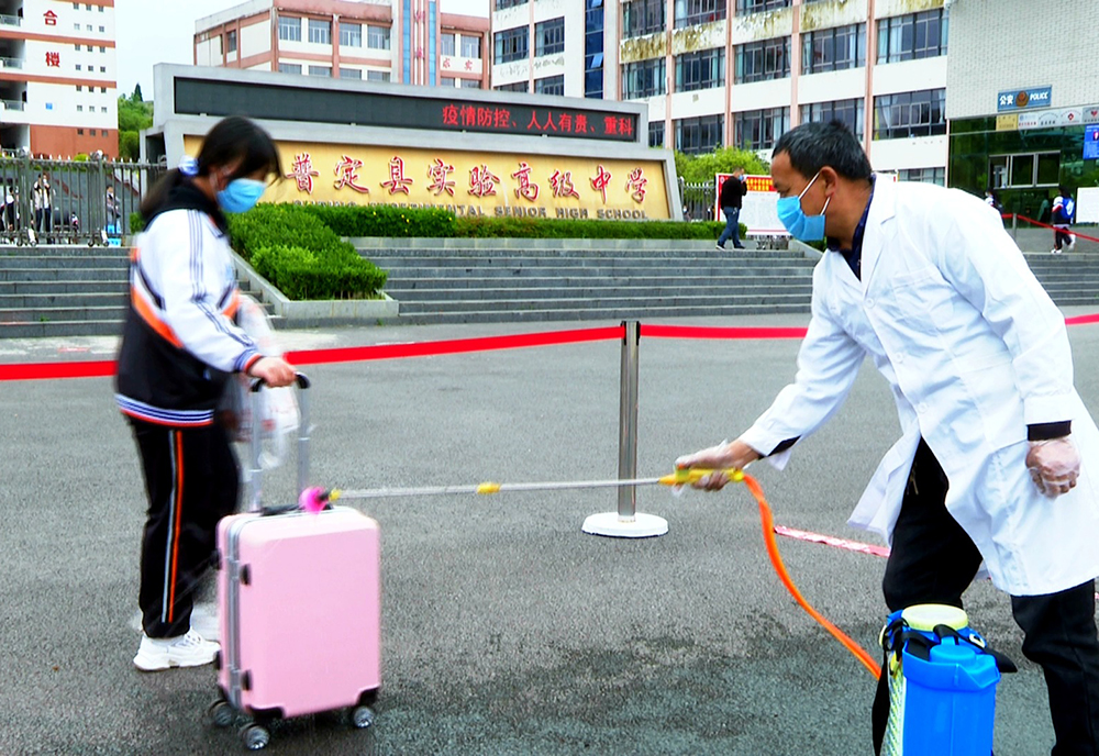 工作人员正在对返校学生的行李进行消毒.jpg