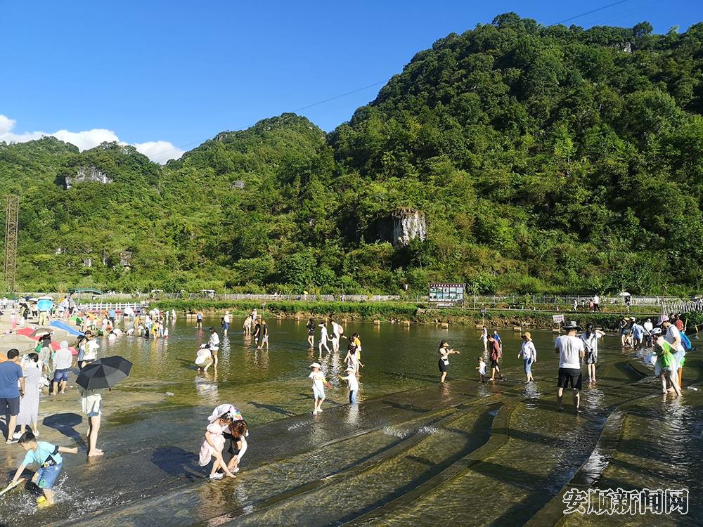 十里荷廊景区，游客在鱼鳞瀑布欢快戏水.jpg